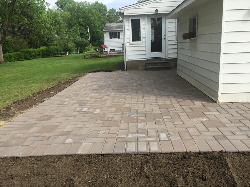 professionally installed tan rectangular pavers against white home